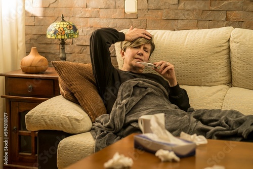 Fotografie Woman looking at the thermometer with a concerned look on her face