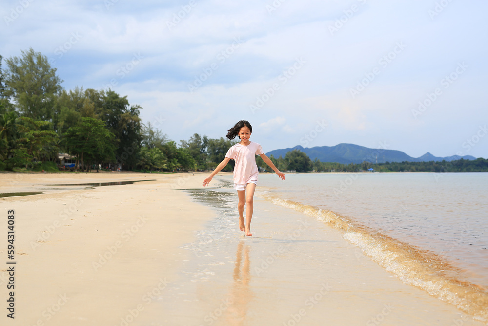 Portrait of Asian young girl kid running on tropical sand beach