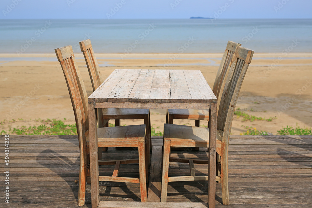 Empty wood table and chairs at restaurants near the beach.