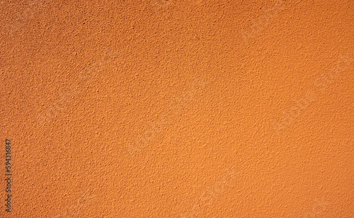 Orange rough concrete wall texture background. Empty orange concrete wall abstract background. Full frame orange cement wall texture background. Blank grain stucco wall. Orange concrete material.