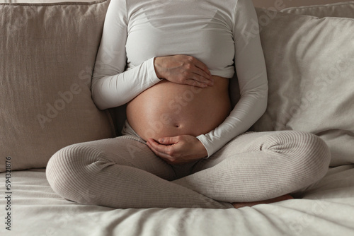 Pregnant woman holding her exposed belly