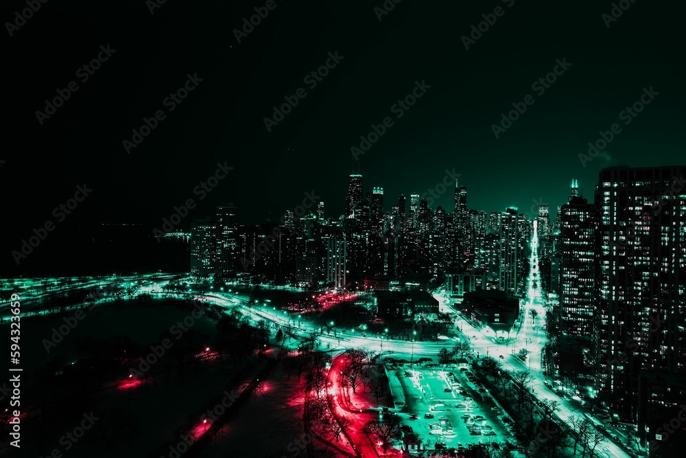View of Chicago at night, showcasing the illuminated skyline of the city's towering skyscrapers View of Chicago at night, showcasing the illuminated skyline of the city's towering skyscrapers