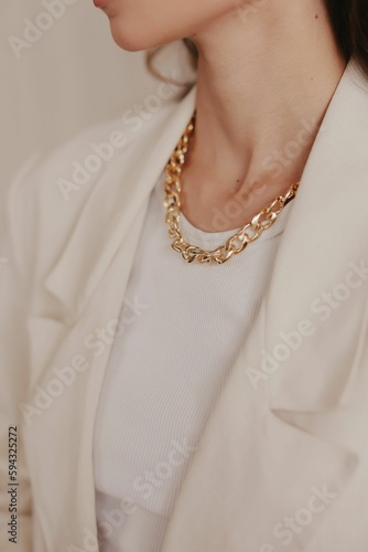 Vertical shot of a woman showing her jewelry against a blurred beige background