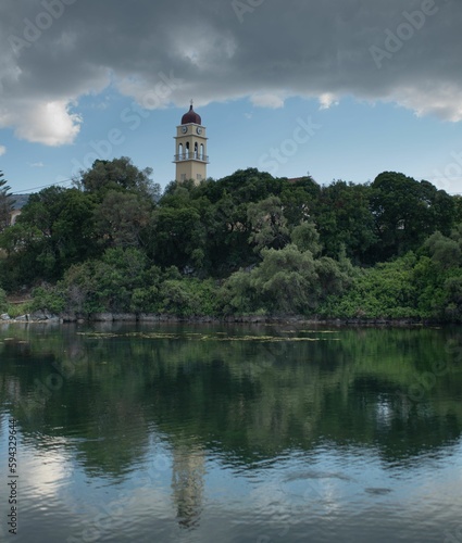 the large clock tower in the middle of a lake with many trees
