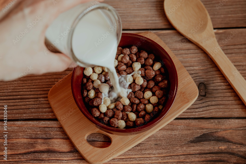 Corn balls for breakfast with milk on a wooden background