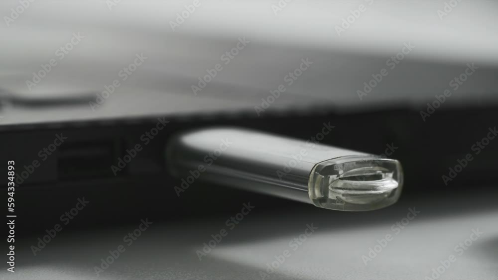 technology, woman hand includes a flash drive for data transfer in a laptop, red light flashes on a flash drive, close-up technology, woman hand includes a flash drive for data transfer in a laptop, red light flashes on a flash drive, close-up