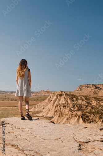 girl with dress standing in the desert of the Bardenas Reales of Navarra in summer