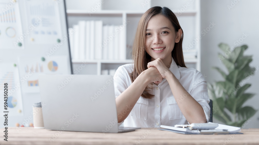 Confident Asian businesswoman calculating finances in the accounting and balance sheet work of the stock market and international exchange rates, Authorized Share Capital, Owners Equity, Common Stock Confident Asian businesswoman calculating finances in the accounting and balance sheet work of the stock market and international exchange rates, Authorized Share Capital, Owners Equity, Common Stock