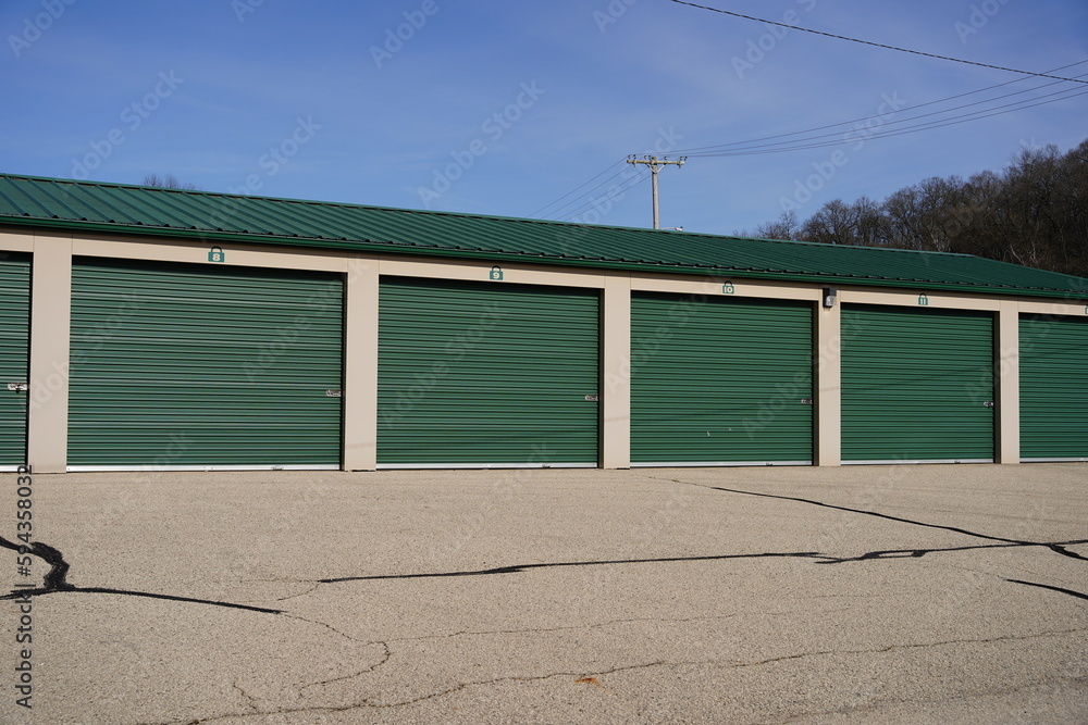 Green and white storage units are being used to hold rental property and belongings. Green and white storage units are being used to hold rental property and belongings.