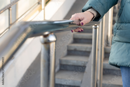 Photo woman holding on to the railing going down the stairs