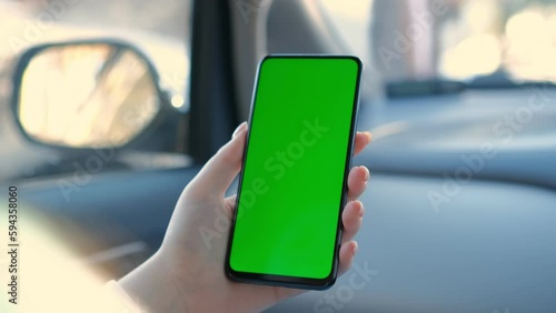 Close up of a woman's hand holding a mobile telephone with a vertical green screen in car chroma key smartphone technology cell phone street touch message display hand