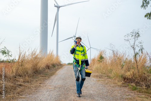 Engineer working at windmill farm,Generating electricity clean energy.