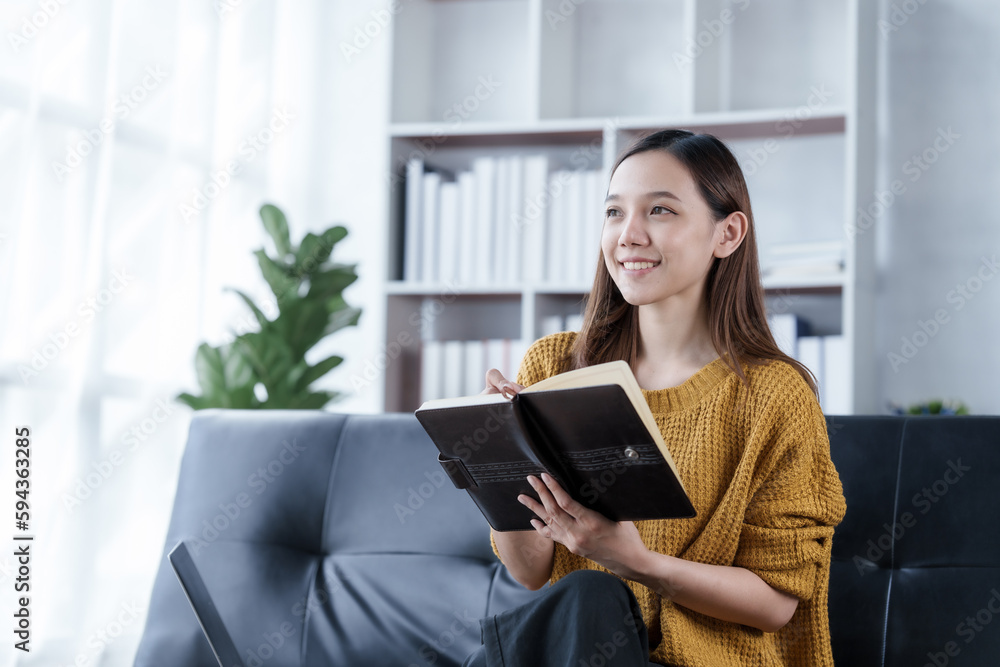 Reading a book, Pretty young asian woman housewife relax on comfortable sofa feels satisfied accomplish chores housework concept Reading a book, Pretty young asian woman housewife relax on comfortable sofa feels satisfied accomplish chores housework concept