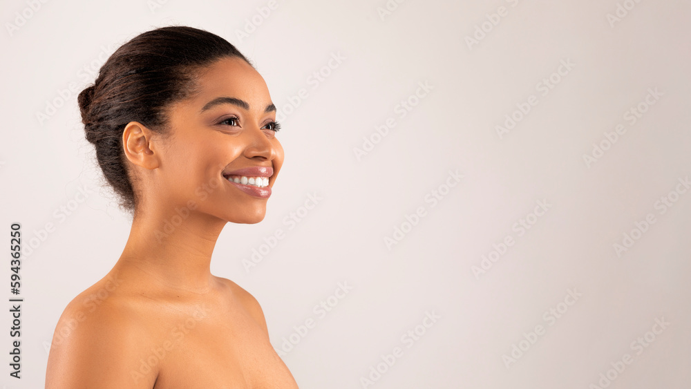 Obraz premium Happy millennial black woman posing topless, looking at copy space