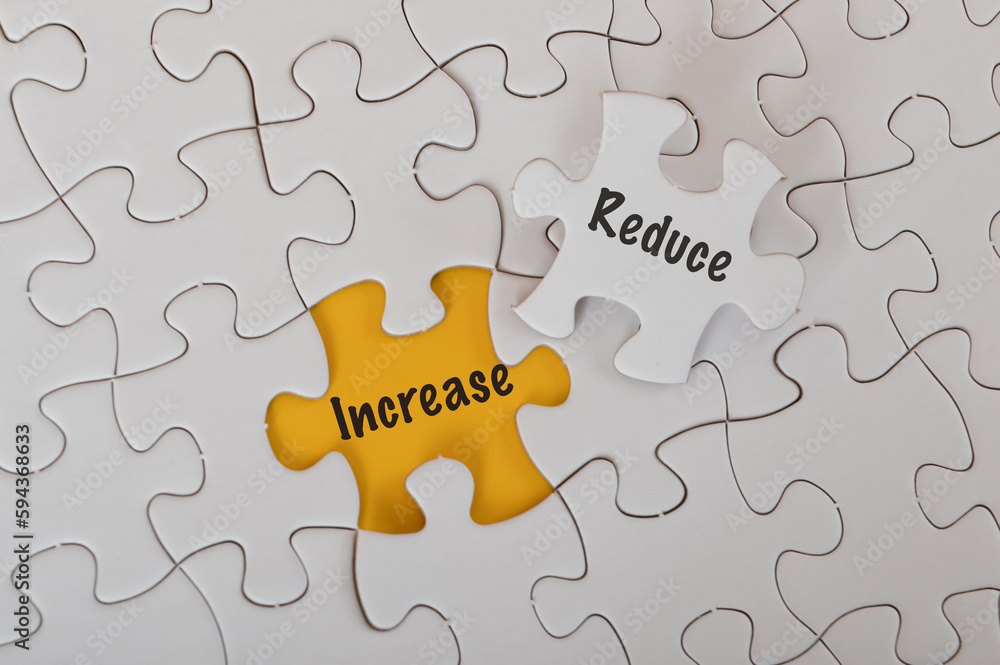 Jigsaw puzzles with text REDUCE and INCREASE isolated on a yellow background. Jigsaw puzzles with text REDUCE and INCREASE isolated on a yellow background.