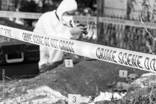 Forensic science specialist photographing at crime scene investigation