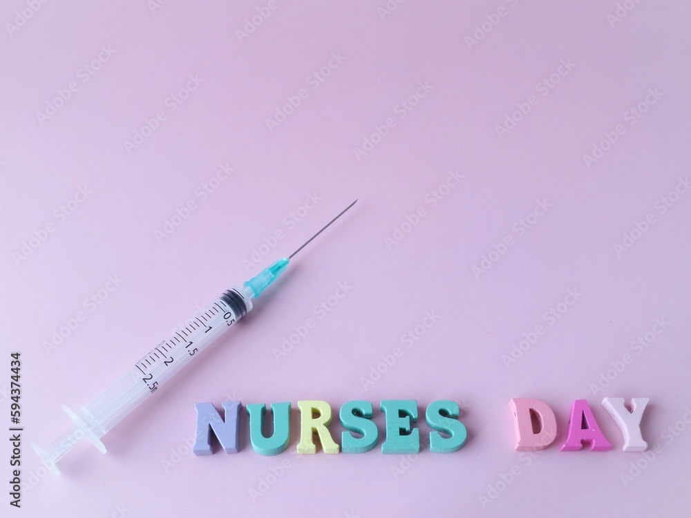 A syringe on a pink background and the words nurses day Concept of nurses day A syringe on a pink background and the words nurses day Concept of nurses day