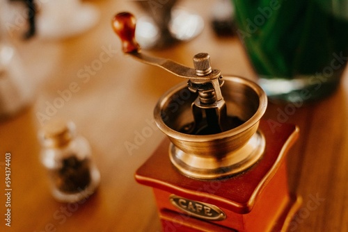 Vintage coffee grinder on a wooden table next to coffee beans on the table