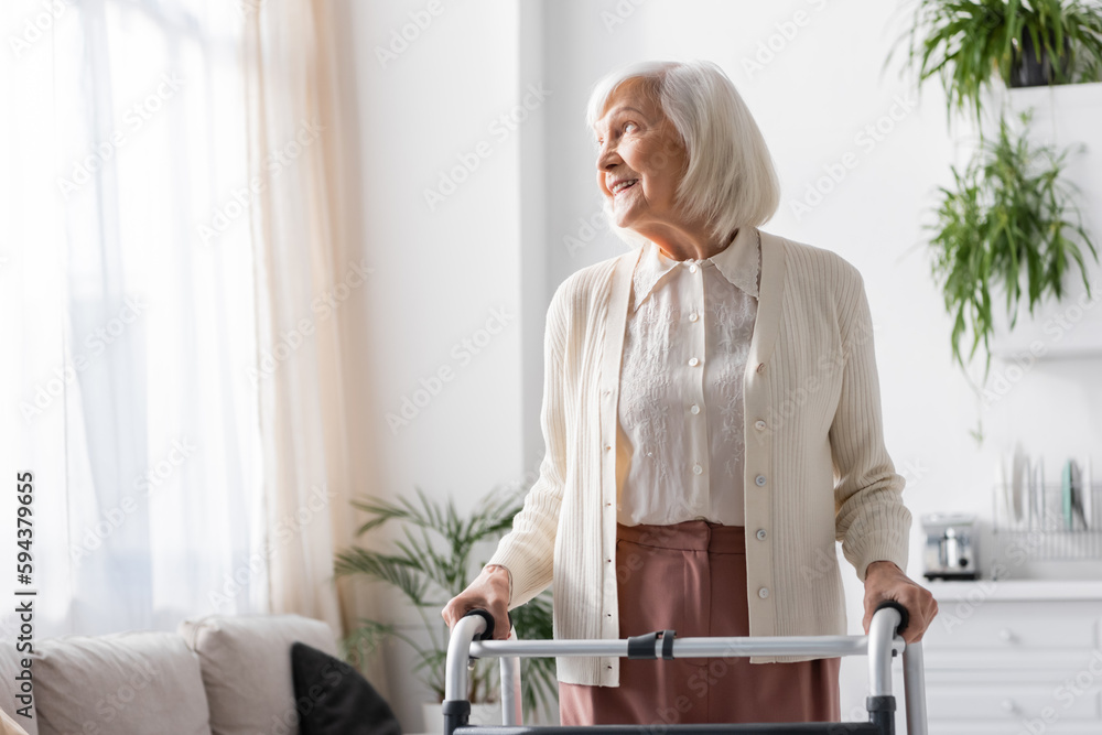 happy senior woman with grey hair walking with help of walker at home. happy senior woman with grey hair walking with help of walker at home.