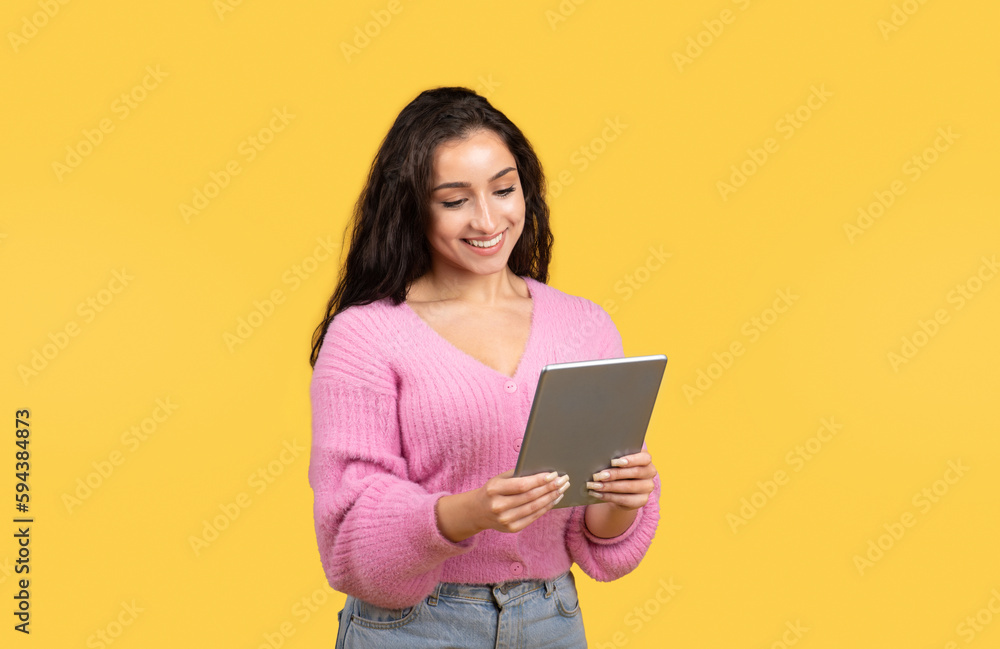 Happy millennial middle eastern lady manager or student typing on tablet, chatting in social networks Happy millennial middle eastern lady manager or student typing on tablet, chatting in social networks