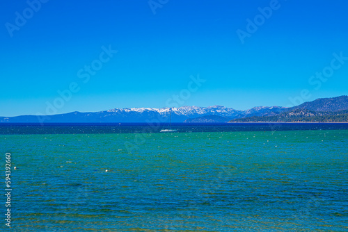 View of Lake Tahoe from Shore looking towards Mt. Rose and Incline Village, with a a saliboat mid frame photo