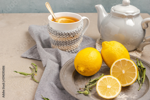 Cup of tea and lemon. A cup of tea with lemon, mint, ginger and honey on on grey table