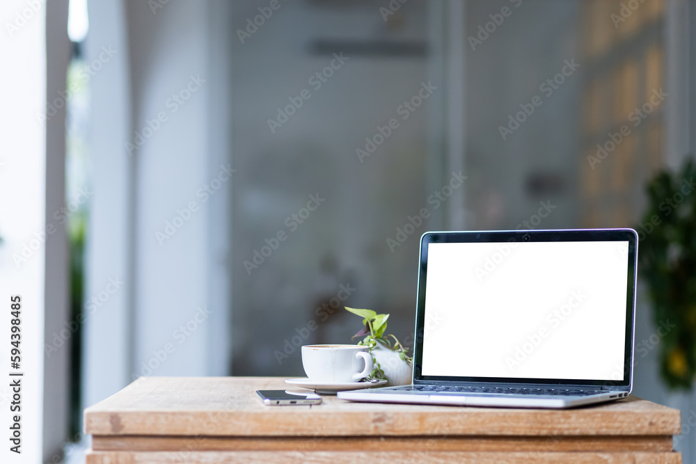 Mockup of laptop computer with empty screen with coffee cup and smartphone on table of the coffee shop background,White screen