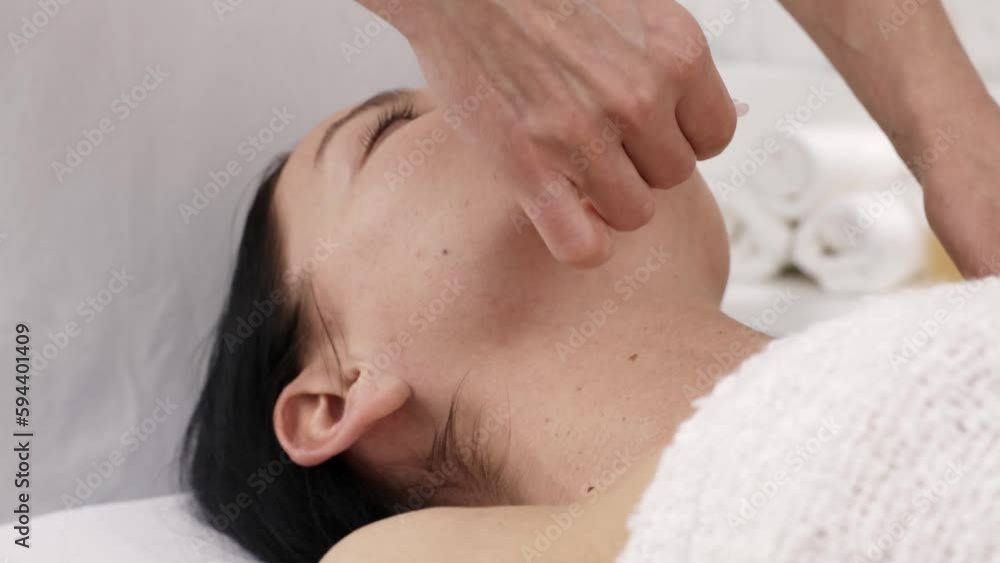 Beautiful young woman doing facial massage using gouache. Beautiful young woman doing facial massage using gouache.