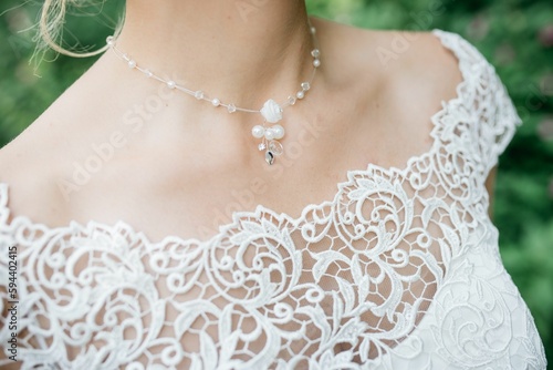 Bride wearing a necklace featuring a floral pendant