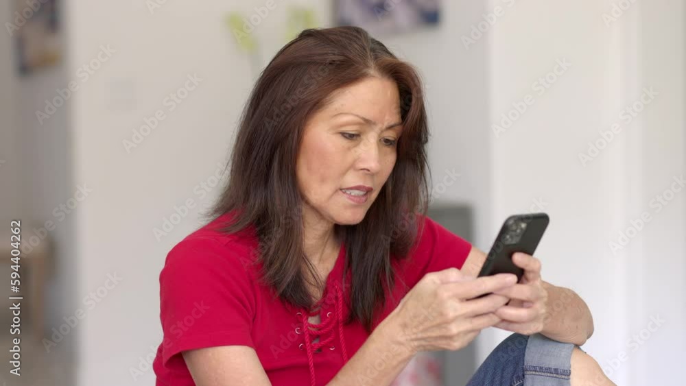 Close up attractive woman in red top smiling enjoying checking email messages on mobile cell phone Close up attractive woman in red top smiling enjoying checking email messages on mobile cell phone