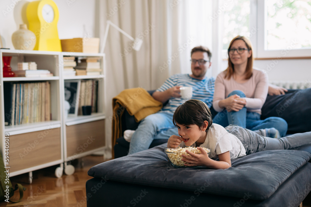 Watching television together in the living room. Family time. Watching television together in the living room. Family time.