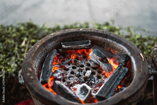 Silver-colored metallic can with burning coals inside