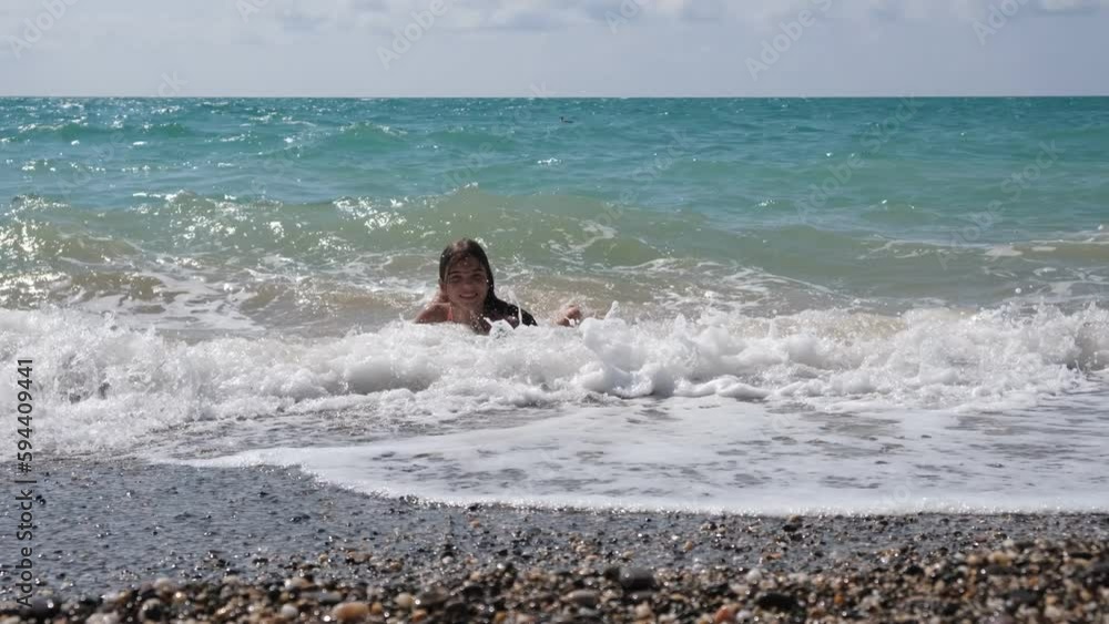 Teenage girl swimming in the sea, having fun, splashing water. A family's Summer Trip. Video 4K. Teenage girl swimming in the sea, having fun, splashing water. A family's Summer Trip. Video 4K.