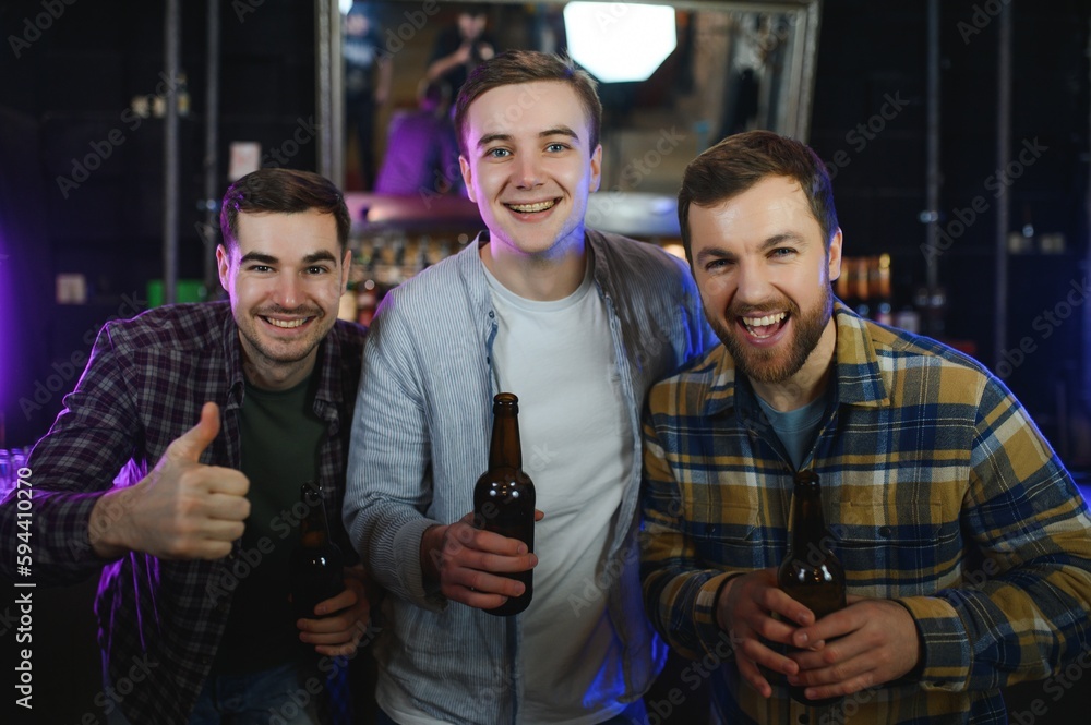 Fototapeta premium Friends resting in the pub with beer in hands. Having conversation.