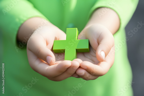 Enfant tenant dans ses mains une croix verte représentant la santé » IA générative