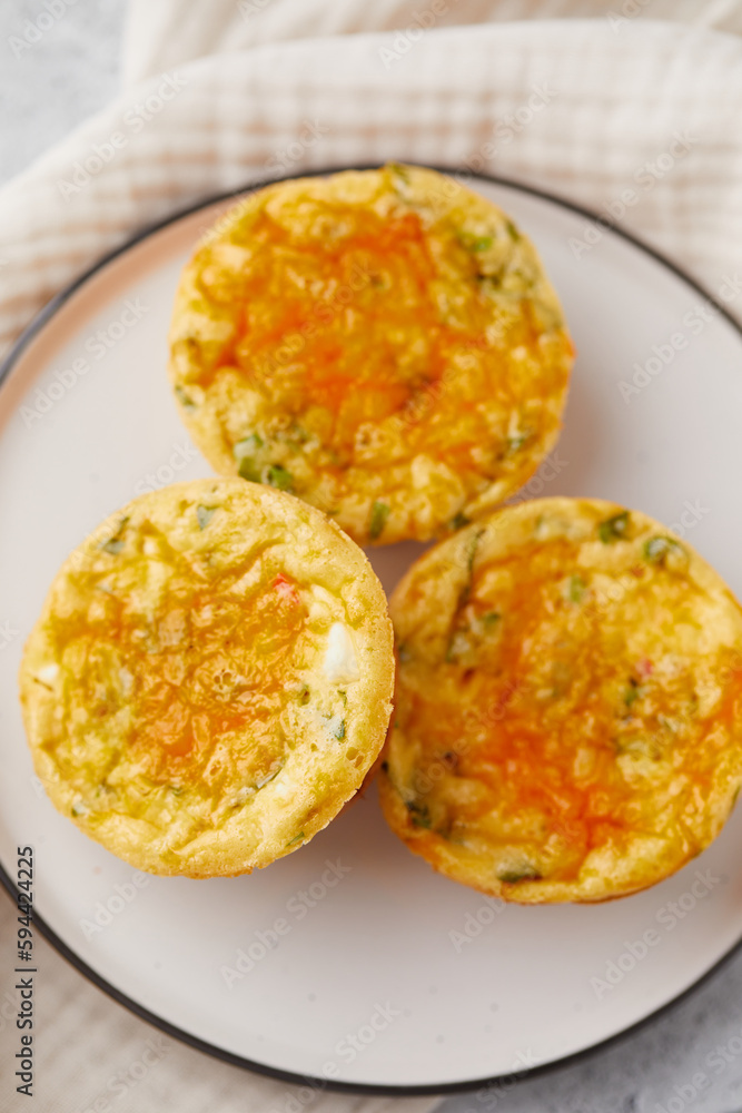 Savory muffins with egg, feta cheese, cheddar and spinach on light background Savory muffins with egg, feta cheese, cheddar and spinach on light background