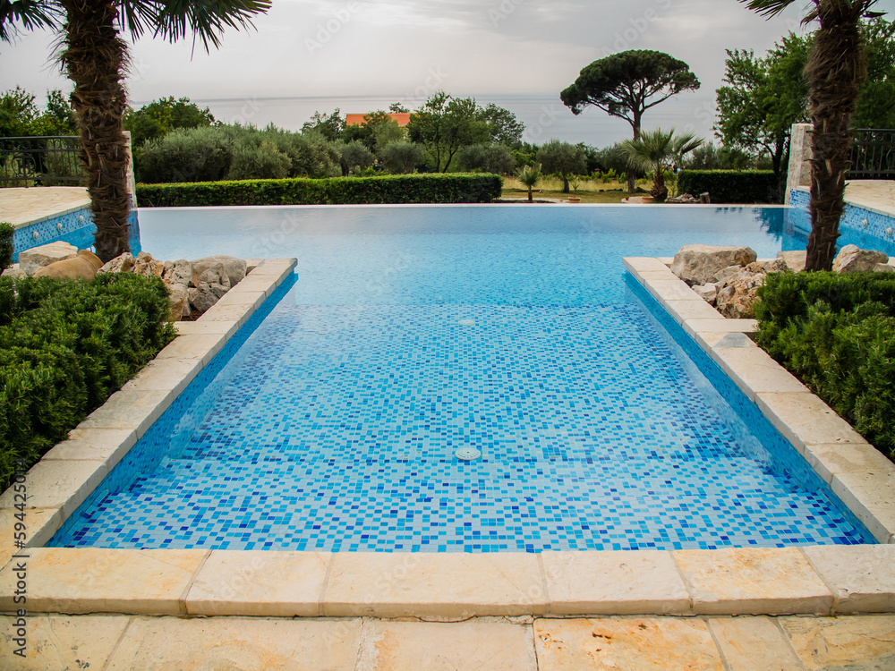 Home swimming pool in garden and villa terrace - summer holidays and luxury lifestyle concept