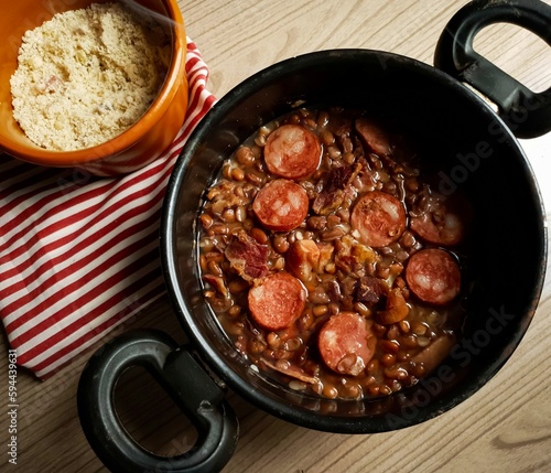 fresh bean in black pot with bacon and calabrian and wooden background photo
