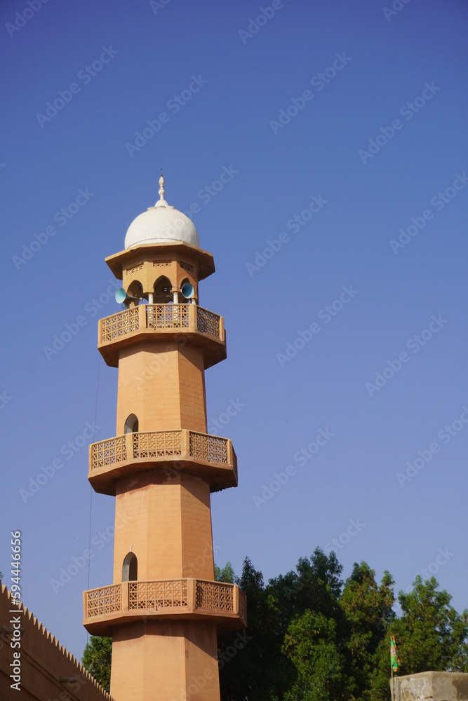 A tower with a white dome and a blue sky
