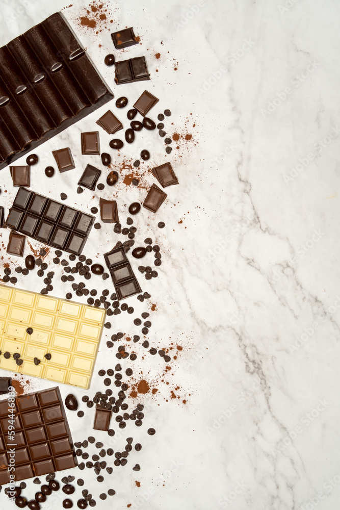 View from above of chocolate bars of different types of chocolate, dark, milk and white on a stone top. High quality photo