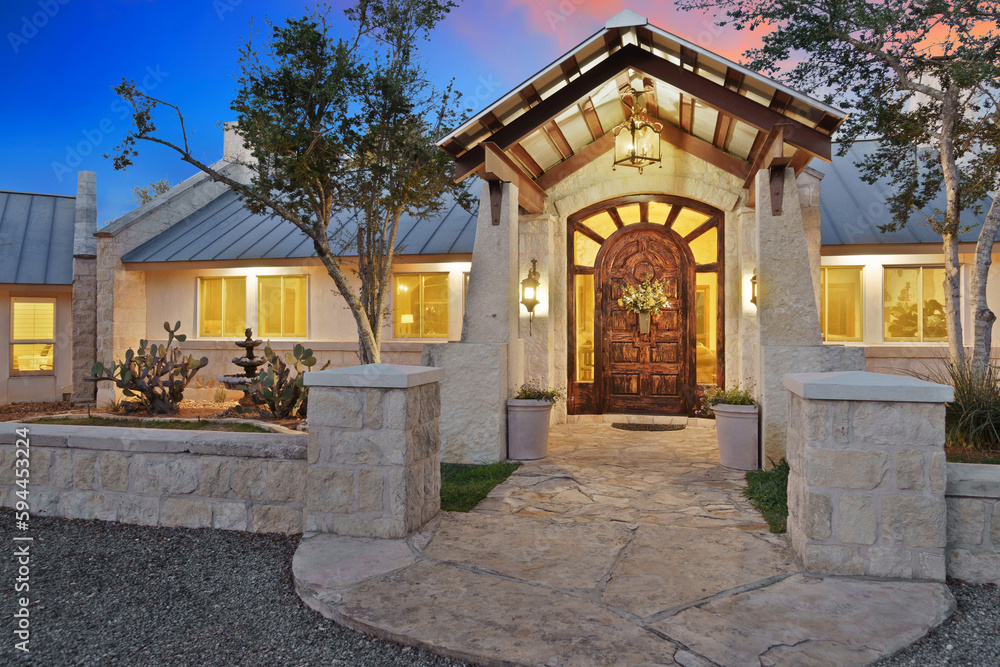 the entrance to a large home at sunset 