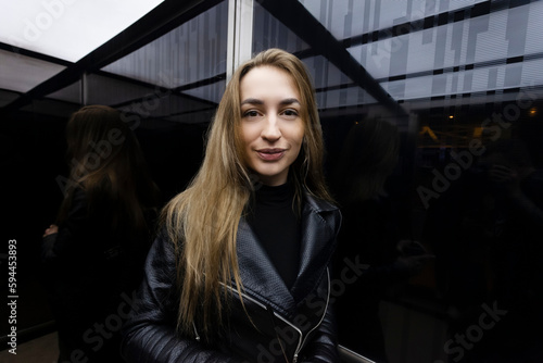 Portrait of a lovely young woman in the black elevator of a modern building. © Georgi
