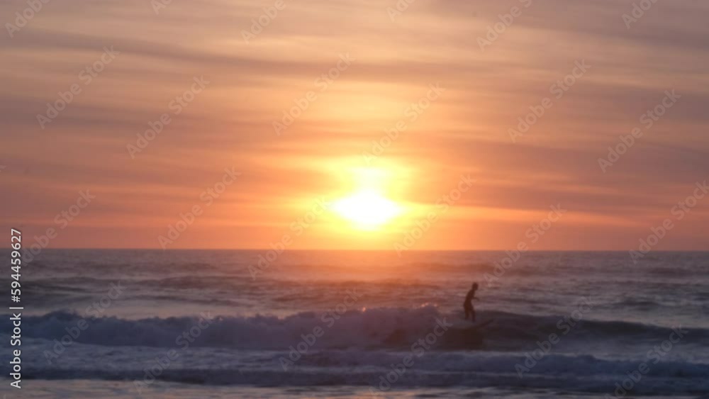 blurred video of a beautiful orange sunset on the beach with surfers blurred video of a beautiful orange sunset on the beach with surfers