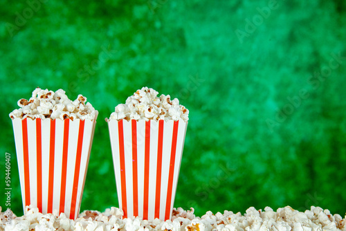 front view fresh popcorn in white and red striped packages on the green background snack cinema cips photo corn movie color free space
