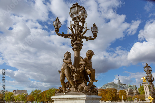 Paris. Decorative street lamp on Pont Alexandre III, along River Seine. Grand Palais in background.