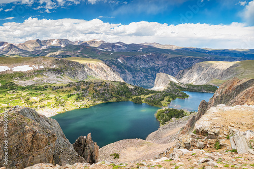 Twin Lakes in the alpine high mountain landscape of Beartooth Mountain Range in Montana with blue sky and white clouds.