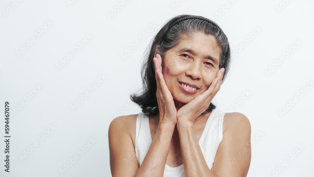 Close up face of female elderly mature older asian chinese housewife applies anti aging facial cream on face, old skincare treatment Close up face of female elderly mature older asian chinese housewife applies anti aging facial cream on face, old skincare treatment