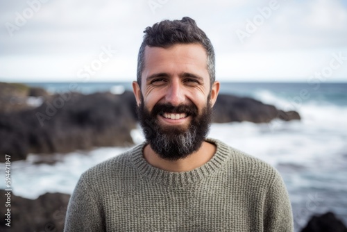 Portrait of smiling man standing by the ocean on a sunny day