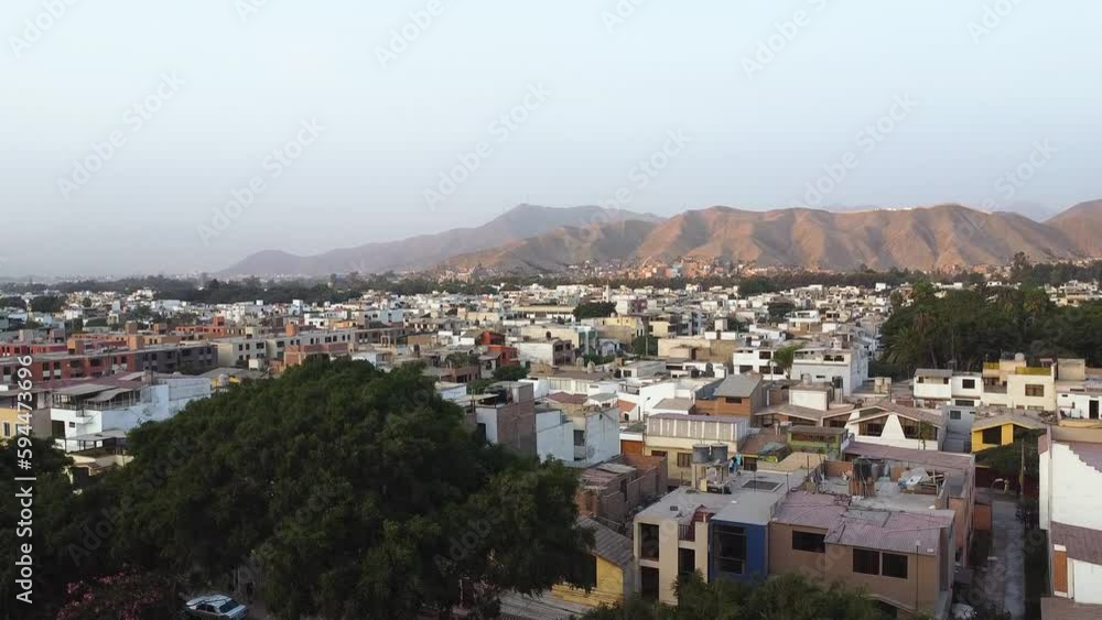 Panoramic view of city in Latin America at sunset, surrounded by hills in the neighborhood of Las Viñas de la Molina, Lima, Peru. Smooth upward movement with drone Panoramic view of city in Latin America at sunset, surrounded by hills in the neighborhood of Las Viñas de la Molina, Lima, Peru. Smooth upward movement with drone