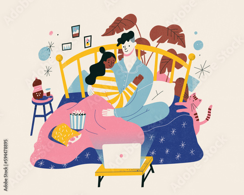 Lovely couple watching movie in bed